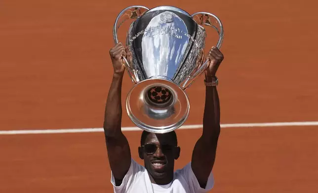PSG's soccer player Ousmane Dembele presents the Champions League trophy during the French Tennis Open at the Roland-Garros stadium in Paris, Monday, June 2, 2025. (AP Photo/Christophe Ena)