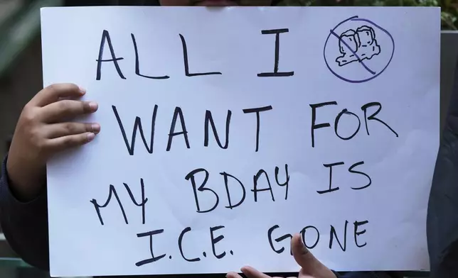 A demonstrator holds a sign outside of Immigration Court, Monday, June 16, 2025, in Chicago. (AP Photo/Nam Y. Huh)