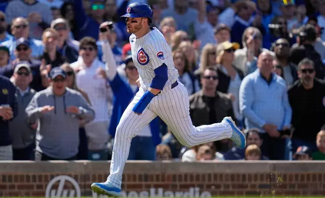 Chicago Cubs' Happ runs home to score on a double by designated hitter Seiya Suzuki (27) during the eighth inning of a baseball game against the Cincinnati Reds, Saturday, May 31, 2025, in Chicago. (AP Photo/Erin Hooley)