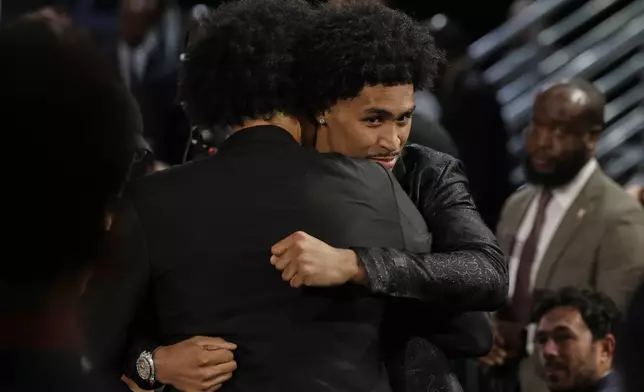 Dylan Harper hugs supporters after being selected second by the San Antonio Spurs In the first round of the NBA basketball draft, Wednesday, June 25, 2025, in New York. (AP Photo/Adam Hunger)