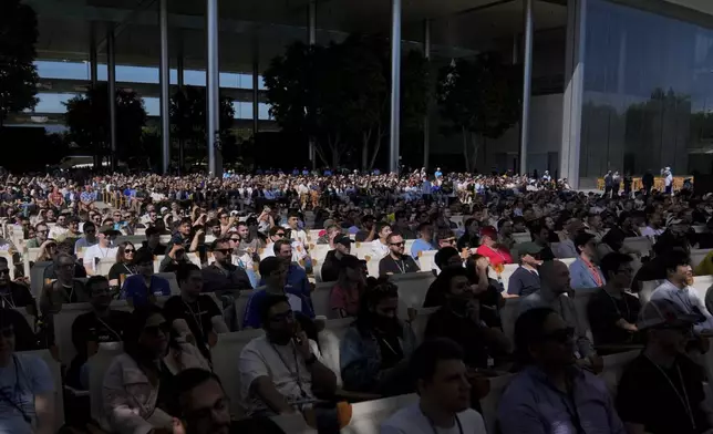 Attendees watch a presentation during an event on the Apple campus in Cupertino, Calif., Monday, June 9, 2025. (AP Photo/Jeff Chiu)