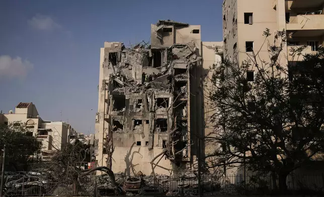Israeli soldiers and a rescue team search for survivors amid the rubble of residential buildings destroyed by an Iranian missile strike that killed several people, in Beersheba, Israel, on Tuesday, June 24, 2025. (AP Photo/Leo Correa)