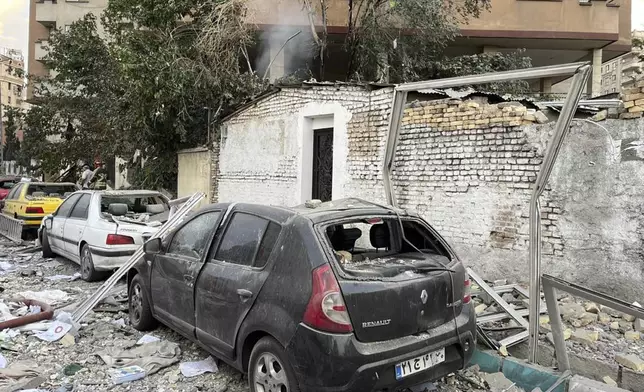 Debris from an apartment building is seen on top of parked cars after a strike in Tehran, Iran, early Friday, June 13, 2025. Israel attacked Iran's capital early Friday, with explosions booming across Tehran.(AP Photo/Vahid Salemi)