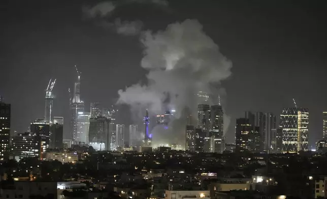 Smoke rises after a missile attack in Tel Aviv, Israel, Friday, June 13, 2025. (AP Photo/Leo Correa)
