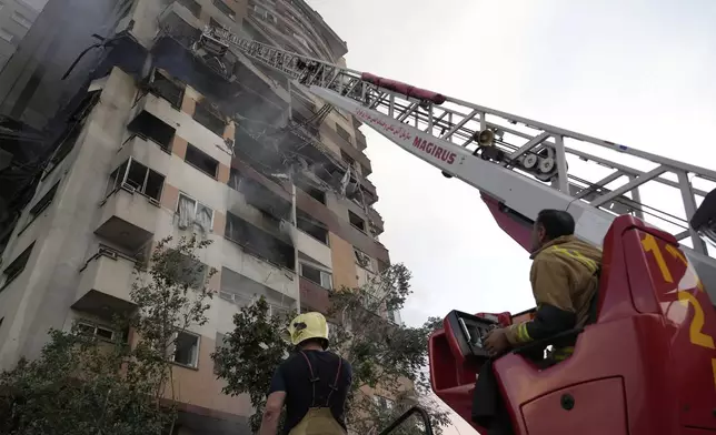 Firefighters work the scene of an explosion at a residence compound in northern Tehran, Iran, Friday, June 13, 2025. (AP Photo/Vahid Salemi)