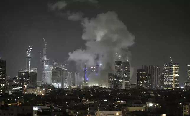 Smoke rises after a missile attack in Tel Aviv, Israel, Friday, June 13, 2025. (AP Photo/Leo Correa)