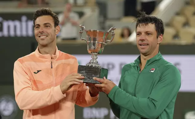 Winners Spain's Marcel Granollers and Argentina's Horacio Zeballos celebrate with the trophy after the men's doubles final match of the French Tennis Open against Britain's Joe Salisbury and Neal Skupski at the Roland-Garros stadium in Paris, Saturday, June 7, 2025. (AP Photo/Aurelien Morissard)