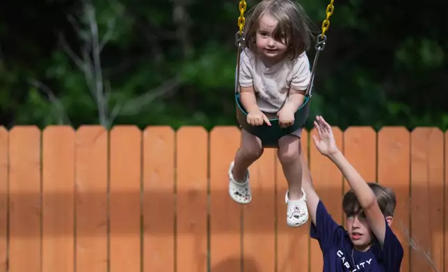 Jude, who is diagnosed with autism, plays with his sister Billie in their backyard, Monday, May 12, 2025, in Austin, Texas. (AP Photo/Eric Gay)