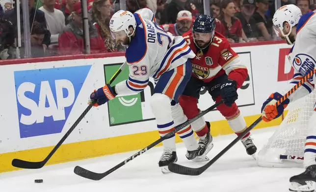 FILE - Edmonton Oilers center Leon Draisaitl (29) and Florida Panthers center Sam Reinhart (13) go after the puck during the third period of Game 7 of the NHL hockey Stanley Cup Final, Monday, June 24, 2024, in Sunrise, Fla. (AP Photo/Wilfredo Lee, File)