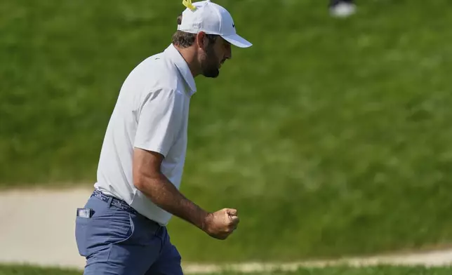 Scottie Scheffler pumps his fist as he sinks a putt on the 14th green during the final round of the Memorial golf tournament Sunday, June 1, 2025, in Dublin, Ohio. (AP Photo/Sue Ogrocki)