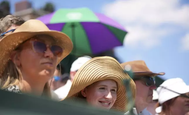 People watch tennis during the Wimbledon Tennis Championships in London, Monday, June 30, 2025. (AP Photo/Kin Cheung)