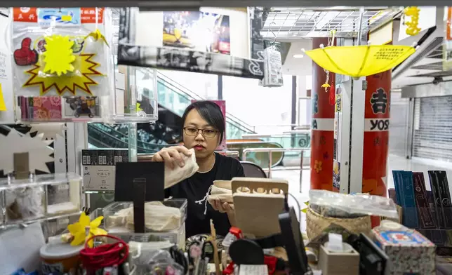 Chan Kim Kam, former pro-democracy district councillor, works at her stall selling incense and essential oils in Hong Kong, Friday, June 20, 2025. (AP Photo/Chan Long Hei)