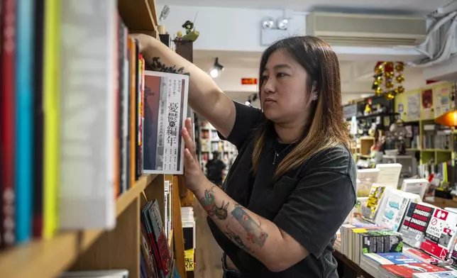Leticia Wong, former pro-democracy district councillor, arranges books at her bookstore in Hong Kong, Friday, June 20, 2025. (AP Photo/Chan Long Hei)