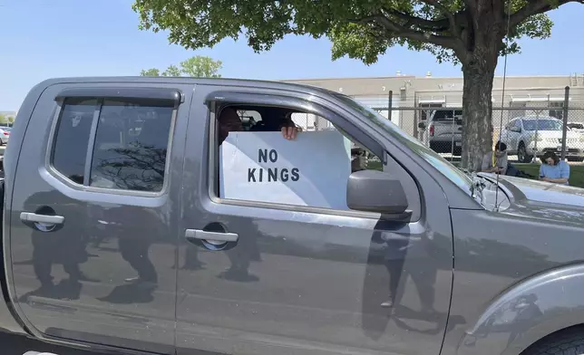 A person holds a sign outside of Glenn Valley Foods, a meat packaging company that was raided by U.S. Immigration and Customs Enforcement on Tuesday, June 10, 2025, in Omaha, Neb. (AP Photo/Margery A. Beck)