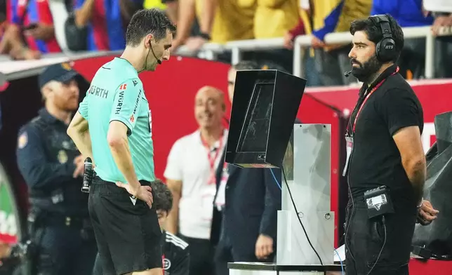 FILE - Referee Ricardo De Burgos Bengoetxea watches the VAR during the Spanish Copa del Rey final soccer match between Barcelona and Real Madrid at Estadio de La Cartuja stadium in Seville, Spain, Saturday, April 26, 2025. (AP Photo/Jose Breton, file)