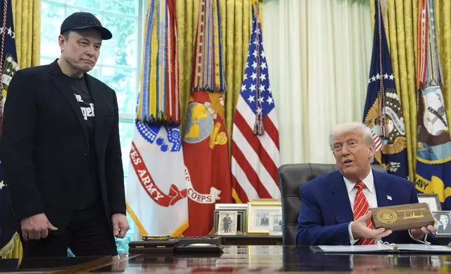 President Donald Trump speaks as he holds a box containing a key before presenting it to Elon Musk, left, during a news conference in the Oval Office of the White House, Friday, May 30, 2025, in Washington. (AP Photo/Evan Vucci)
