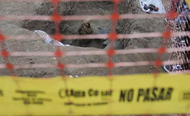 An ancient mummy which archeologists identify as female and from the pre-Inca Chancay culture is partially excavated after being discovered by city workers digging a natural gas line for the company Calidda in the district of Puente Piedra on the outskirts of Lima, Peru, Wednesday, June 18, 2025. (AP Photo/Martin Mejia)