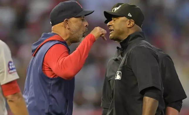 Boston Red Sox manager Alex Cora, left, argues with umpire Alan Porter, front right, as umpire Jim Wolf, back right, looks on after he was ejected in the fifth inning during a baseball game against the Los Angeles Angels, Monday, June 23, 2025, in Anaheim, Calif. (AP Photo/Jayne Kamin-Oncea)