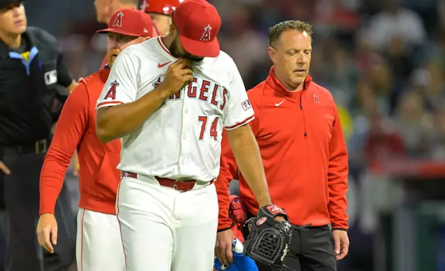 Los Angeles Angels relief pitcher Kenley Jansen walks with Angels' pitching coach Barry Enright, back and Angels' trainer Mike Frostad as he leaves the game during the ninth inning of a baseball game against the Boston Red Sox, Monday, June 23, 2025, in Anaheim, Calif. (AP Photo/Jayne Kamin-Oncea)