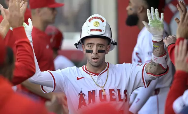 Los Angeles Angels' Zach Neto is congratulated in the dugout after hitting a solo home run during the first inning of a baseball game against the Boston Red Sox, Monday, June 23, 2025, in Anaheim, Calif. (AP Photo/Jayne Kamin-Oncea)