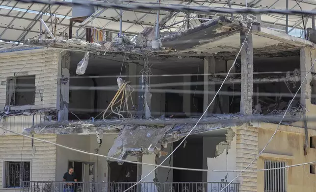 A man checks his destroyed house that was hit in an Israeli airstrike in Nabatieh town, south Lebanon, Friday, June 27, 2025. (AP Photo/Mohammed Zaatari)