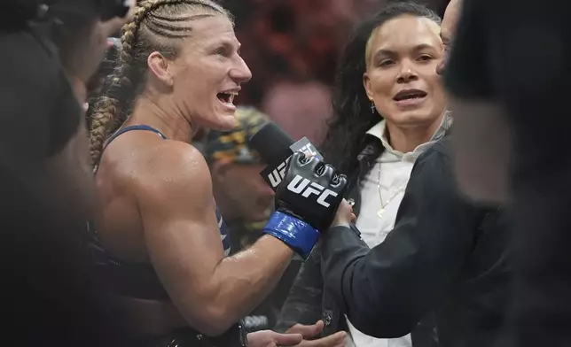Kayla Harrison, left, talks to Amanda Nunes after her women's bantamweight bout against Julianna Peña at the UFC 316 mixed martial arts event Sunday, June 8, 2025 in Newark, N.J. (AP Photo/Frank Franklin II)