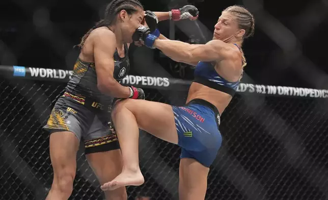 Kayla Harrison, right, punches Julianna Peña during the second round of a women's bantamweight bout at the UFC 316 mixed martial arts event Sunday, June 8, 2025 in Newark, N.J. (AP Photo/Frank Franklin II)