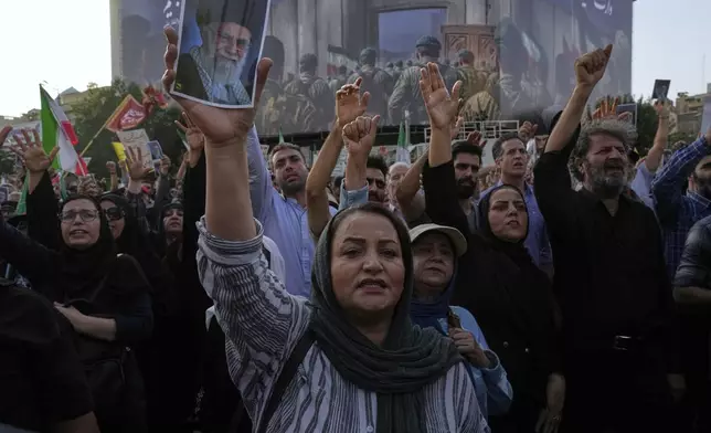 Protesters chant slogans as one of them holds up a poster of the Iranian Supreme Leader Ayatollah Ali Khamenei in a protest following the U.S. attacks on nuclear sites in Iran, in Tehran, Iran, Sunday, June 22, 2025. (AP Photo/Vahid Salemi)