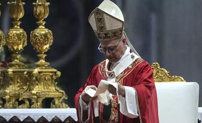 Pope Leo XIV look at a pallium, he blessed for the new metropolitan archbishops during a Mass in St. Peter's Basilica at the Vatican, Sunday, June 29, 2025. (AP Photo/Andrew Medichini)
