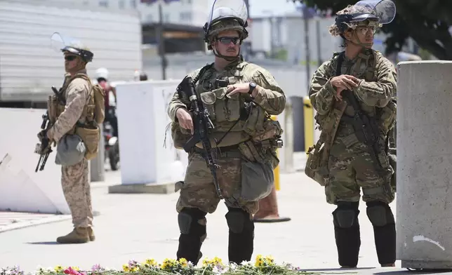 Members of the California National Guard and U.S. Marines guard a federal building on Tuesday, June 17, 2025, in Los Angeles. (AP Photo/Damian Dovarganes)