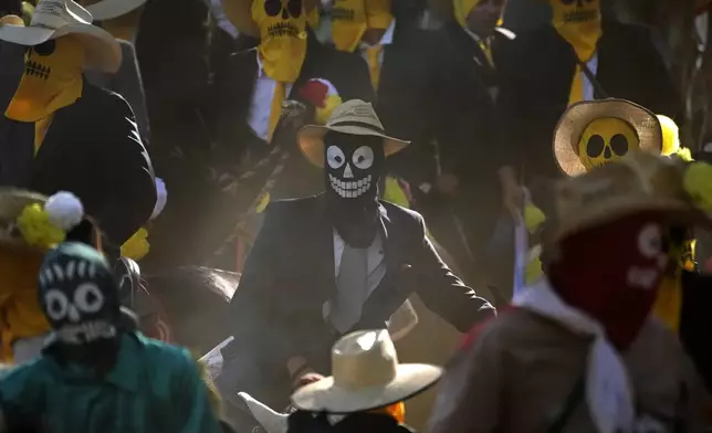Masked revelers take part in the Cavalhadas, or Holy Spirit, Festival in Pirenopolis, Goias state, Brazil, Sunday, June 8, 2025. (AP Photo/Eraldo Peres)