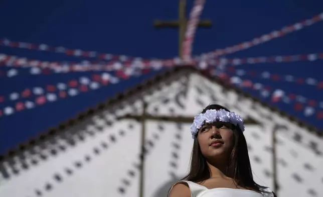 A girl stands in front of the church of Our Lady of the Rosary during the Cavalhadas, or Holy Spirit, Festival, in Pirenopolis, Goias state, Brazil, Sunday, June 8, 2025. (AP Photo/Eraldo Peres)