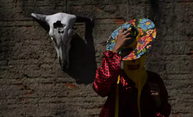 A reveler wears a hat and costume during the Cavalhadas, or Holy Spirit, Festival, in Pirenopolis, Goias state, Brazil, Sunday, June 8, 2025. (AP Photo/Eraldo Peres)