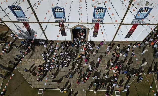 Congregants leave Mass at Our Lady of the Rosary church during the Cavalhadas, or Holy Spirit, Festival in Pirenopolis, Goias state, Brazil, Monday, June 9, 2025. (AP Photo/Eraldo Peres)