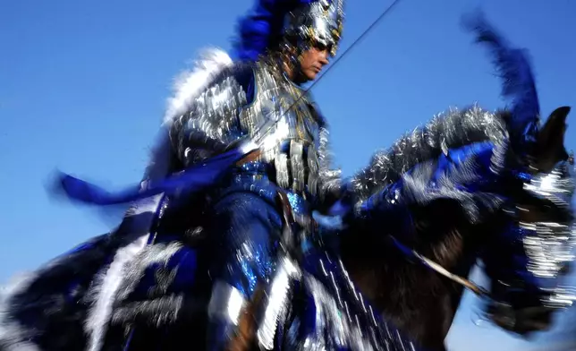 A Christian knight rides a horse during a battle reenactment at the Cavalhadas, or Holy Spirit, Festival in Pirenopolis, Goias state, Brazil, Monday, June 9, 2025. (AP Photo/Eraldo Peres)