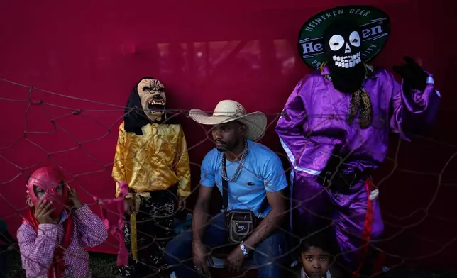 A family wearing costumes attends the Cavalhadas, or Holy Spirit, Festival, in Pirenopolis, Goias state, Brazil, Sunday, June 8, 2025. (AP Photo/Eraldo Peres)