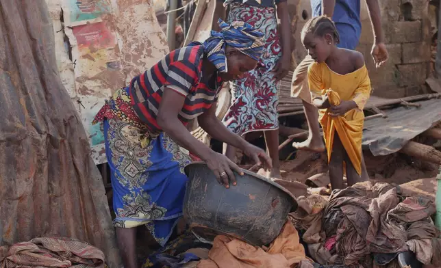 People salvage their belongings in a flooded area after heavy rainfall in the market town of Mokwa, north-central Nigeria, Saturday May 31, 2025. (AP Photo/Usman Salihu Mokwa)