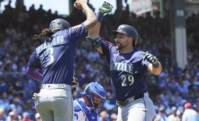 Seattle Mariners' Cal Raleigh, right, celebrates with J.P. Crawford after hitting a two-run home run during the first inning of a baseball game against the Chicago Cubs in Chicago, Sunday, June 22, 2025. (AP Photo/Nam Y. Huh)