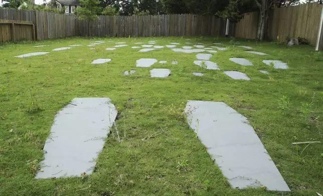 Casket-shaped stones mark the 62 graves identified at the original site of the First Baptist Church of Williamsburg in Williamsburg, Va., on May 30, 2025. (AP Photo/Allen G. Breed)