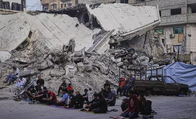 Palestinians gather for Eid al-Adha prayers beside the ruins of Al-Kanz mosque destroyed by Israeli bombardment, in Gaza City on Friday, June 6, 2025. (AP Photo/Jehad Alshrafi)