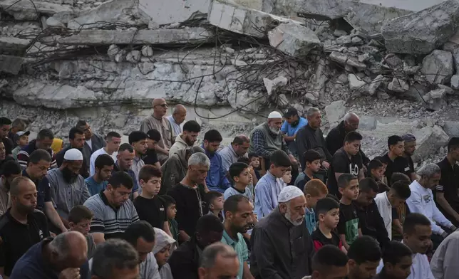 Palestinians offer Eid al-Adha prayers beside the ruins of a mosque destroyed by Israeli bombardment, in Deir al-Balah, Gaza on Friday, June 6, 2025. (AP Photo/Abdel Kareem Hana)