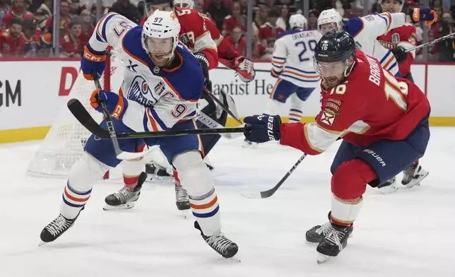 Florida Panthers center Aleksander Barkov (16) defends Edmonton Oilers center Connor McDavid (97) during the first period of Game 3 of the NHL Stanley Cup final Monday, June 9, 2025, in Sunrise, Fla. (AP Photo/Lynne Sladky)