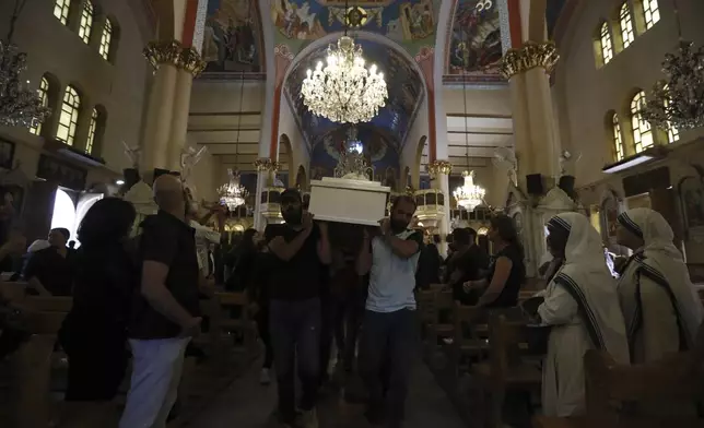 Pallbearers carry the coffin of a victim of Sunday's suicide bombing at Mar Elias Greek Orthodox Church during a funeral service at al-Saleeb Church in the al-Qasaa neighborhood of Damascus, Syria, Tuesday, June 24, 2025. (AP Photo/Omar Sanadiki)