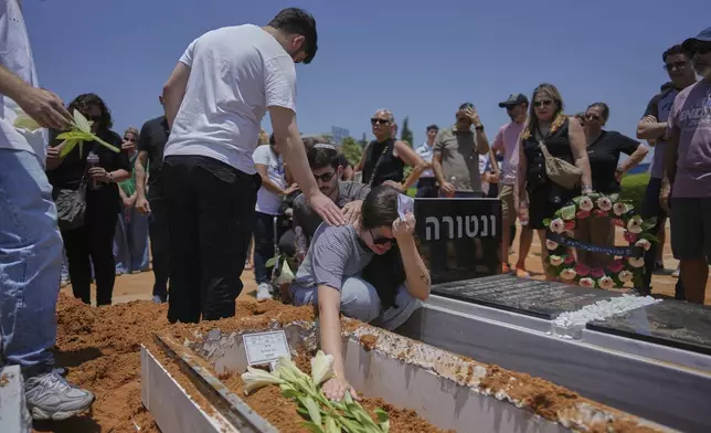 Relatives and friends of Daisy Yitzhaki, 85, who was killed during an Iranian missile attack, mourn during her funeral at Segula cemetery in Petah Tikva, Israel, Wednesday, June 18, 2025. (AP Photo/Oded Balilty)