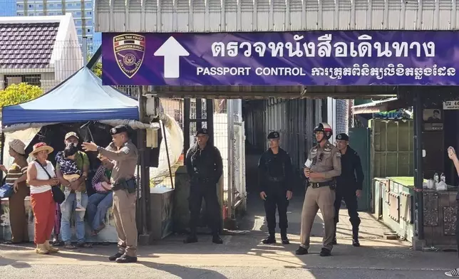 In this photo released by Royal Thai Army, a Thai police officer talks to peoples near a border checkpoint between Thailand and Cambodia, in Sa Kaeo Province, Thailand, Tuesday, June 24, 2025. (Royal Thai Army via AP)