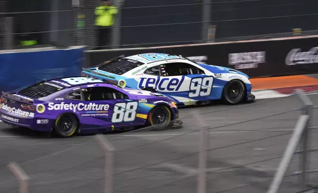 Daniel Suarez (99) and Shane Van Gisbergen (88) drive during a NASCAR Cup Series auto race at Hermanos Rodríguez race track in Mexico City, Sunday, June 15, 2025. (AP Photo/Marco Ugarte)