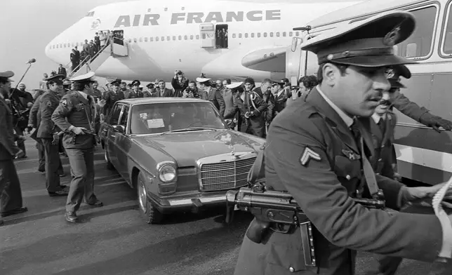 FILE - Ayatollah Ruhollah Khomeini has a heavy escort as he enters car to leave the airport in Tehran, Iran, Feb. 1, 1979, after arriving back in the country on a chartered Air France Boing 747. (AP Photo/FY, File)
