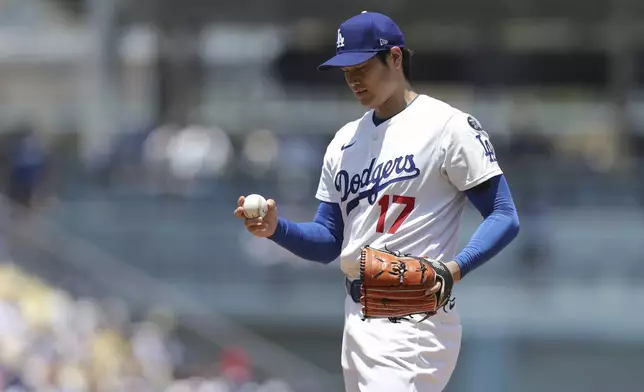 Los Angeles Dodgers starting pitcher Shohei Ohtani looks at the ball before a baseball game against the Washington Nationals in Los Angeles, Sunday, June 22, 2025. (AP Photo/Jessie Alcheh)