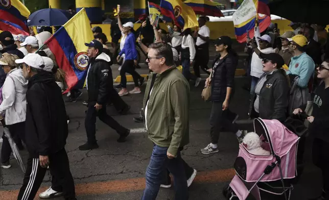 People march to the clinic where Colombian Senator Miguel Uribe Turbay is being treated after he was shot, in Bogota, Colombia, Sunday, June 8, 2025. (AP Photo/Ivan Valencia)