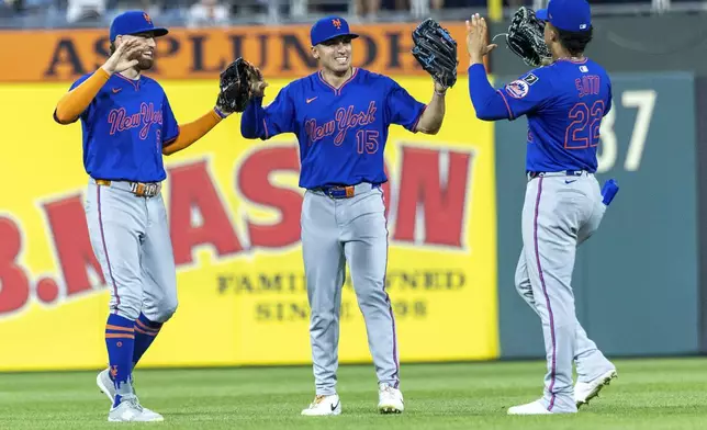 New York Mets left fielder Brandon Nimmo, left, center fielder Tyrone Taylor (15) and right fielder Juan Soto (22) celebrate after they defeated the Philadelphia Phillies in a baseball game, Saturday, June 21, 2025, in Philadelphia. (AP Photo/Laurence Kesterson)